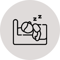 A person sleeping on the bed in their room.
